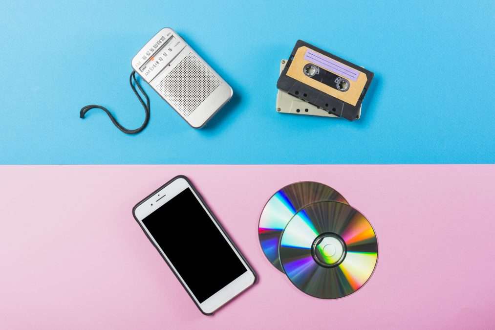 radio cassette cd and cell phone on dual pink and blue colored backdrop