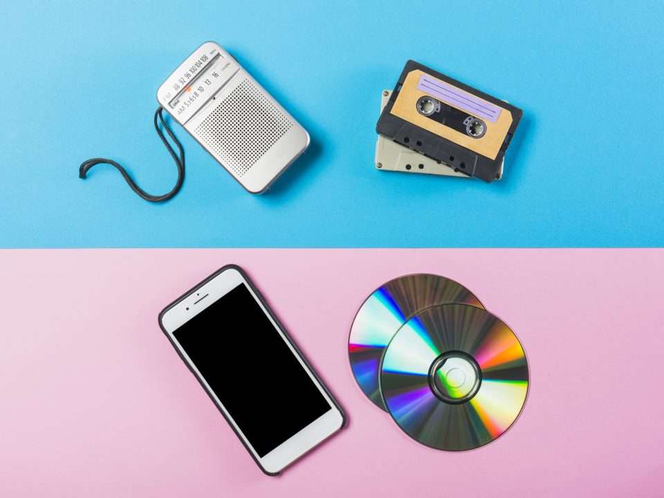 radio cassette cd and cell phone on dual pink and blue colored backdrop