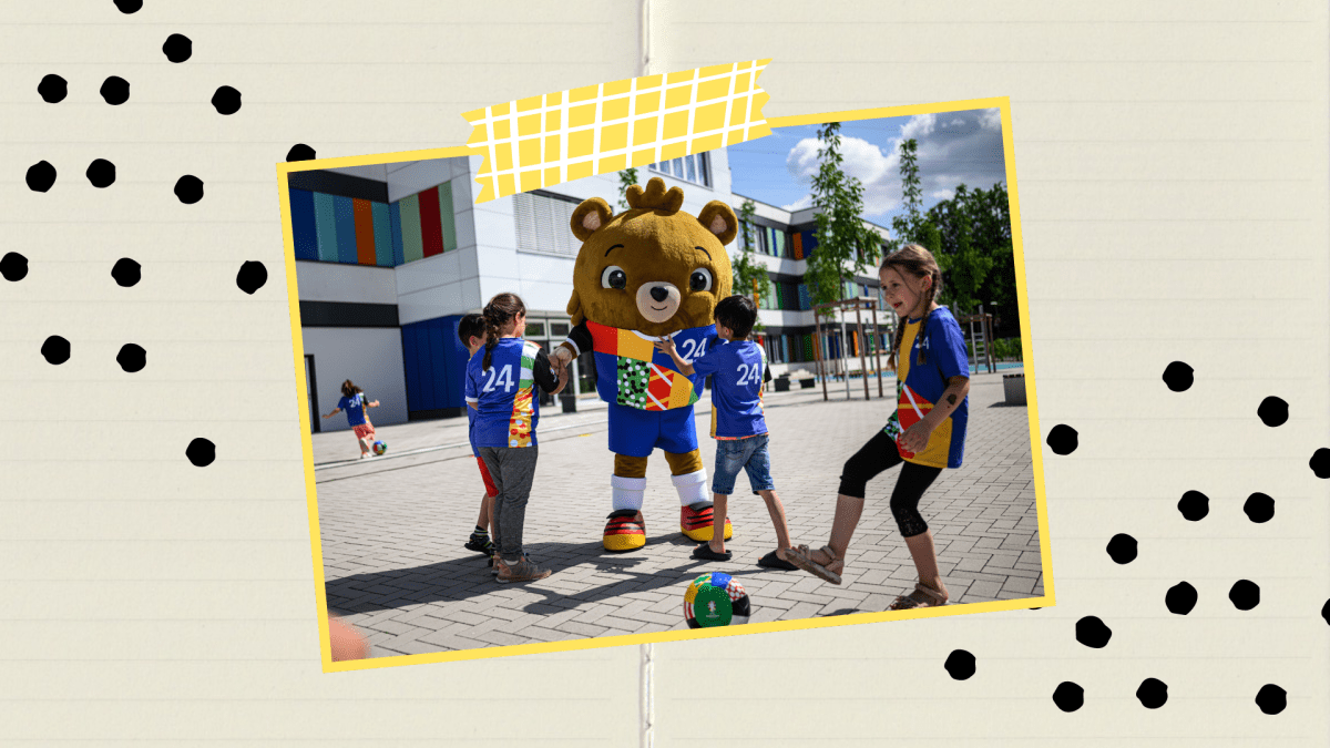 Das Maskottchen Albärt spielt Fusball mit Kindern.