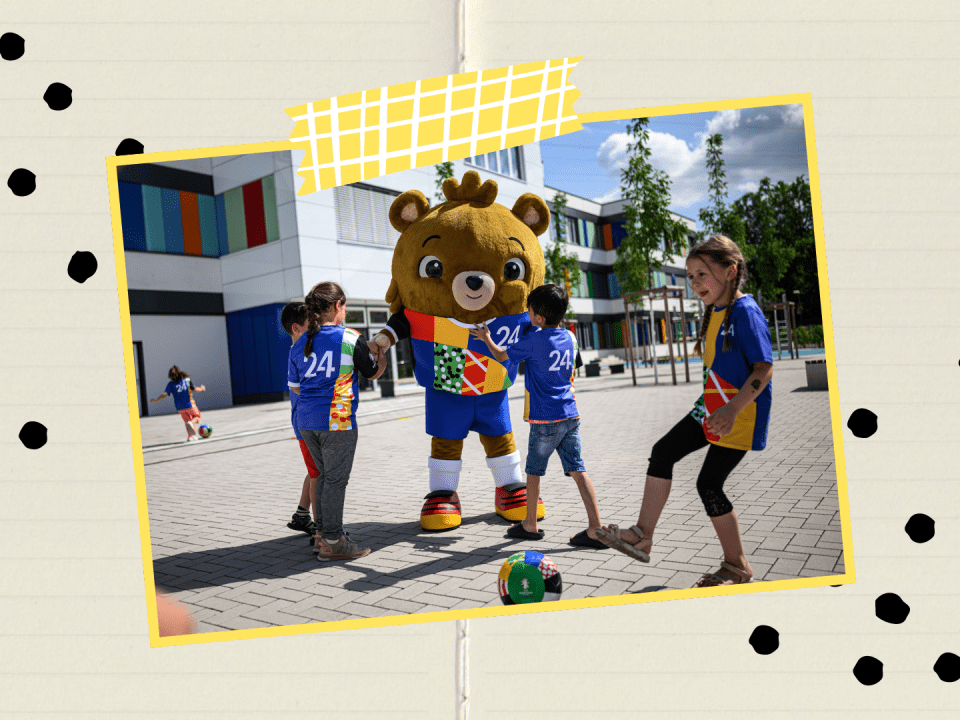 Das Maskottchen Albärt spielt Fusball mit Kindern.